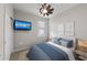 Inviting bedroom featuring a wall-mounted television, ceiling fan, closet, plantation shutters and a comfortable bed at 12897 Oriago St, Venice, FL 34293