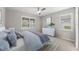 Serene bedroom with a ceiling fan, plantation shutters, plush bedding, and a dresser with modern decor at 12897 Oriago St, Venice, FL 34293
