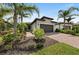 Inviting home with a two car garage, brick driveway, lush landscaping, and a well-manicured lawn at 12897 Oriago St, Venice, FL 34293