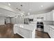 Modern kitchen featuring stainless steel appliances, granite counters, white cabinets and large island at 12897 Oriago St, Venice, FL 34293