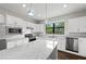 Bright kitchen features white cabinets, stainless appliances, granite counters, and modern pendant lighting at 12897 Oriago St, Venice, FL 34293