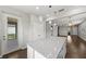 Kitchen island featuring granite countertop, white cabinets and open floor plan with outdoor views at 12897 Oriago St, Venice, FL 34293