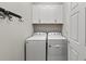 Bright laundry room featuring a modern washer and dryer, complemented by overhead cabinets for convenient storage at 12897 Oriago St, Venice, FL 34293