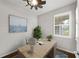 Bright home office featuring a modern desk, plantation shutters, stylish ceiling fan and wood flooring at 12897 Oriago St, Venice, FL 34293