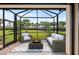 Screened in patio offering comfortable seating around a modern fire pit, perfect for outdoor entertaining at 12897 Oriago St, Venice, FL 34293