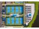 Aerial view showcasing well-maintained pickleball courts with green and blue surfaces, surrounded by seating and landscaping at 12897 Oriago St, Venice, FL 34293