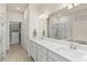 Bright bathroom featuring double sink vanity, large mirror, and walk-in shower and closet at 13202 Borrego St, Venice, FL 34293