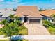 Aerial view of home with paver driveway and two-car garage surrounded by mature landscaping, a meticulously maintained property at 13202 Borrego St, Venice, FL 34293