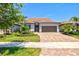 Single-Gathering home with barrel tile roof, paver driveway, and manicured landscaping at 13202 Borrego St, Venice, FL 34293