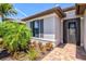 Close-up of the front entrance with decorative glass door and verdant landscaping at 13202 Borrego St, Venice, FL 34293