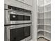 Gourmet kitchen featuring modern double ovens, pantry shelving, and ample storage for a seamless cooking experience at 13202 Borrego St, Venice, FL 34293