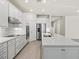 Well-lit kitchen featuring stainless steel appliances, a center island, and modern white cabinetry with sleek hardware at 13202 Borrego St, Venice, FL 34293