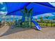 Community playground with a covered play structure on a wood chip surface offers fun and safety for children at 13202 Borrego St, Venice, FL 34293