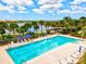 Aerial view of an Olympic-sized community swimming pool with lounge chairs, tables, and blue umbrellas at 13202 Borrego St, Venice, FL 34293