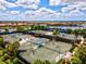 Community aerial view of tennis courts surrounded by lush landscaping and lakes in the background at 13202 Borrego St, Venice, FL 34293