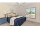 Bright bedroom features a ceiling fan, tile floors, and a large window offering plenty of natural light at 13648 Clara Ln, Port Charlotte, FL 33981