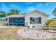 Charming home exterior featuring a screened lanai, bright windows, and a well-maintained gravel yard at 13648 Clara Ln, Port Charlotte, FL 33981