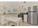 Bright kitchen featuring white cabinets, stainless steel appliances, and a unique round window above the sink at 13648 Clara Ln, Port Charlotte, FL 33981