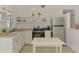 Bright kitchen featuring white cabinets, stainless steel appliances, and open shelving above the sink at 13648 Clara Ln, Port Charlotte, FL 33981