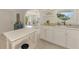 Bright kitchen featuring white cabinets, stainless steel appliances, and a unique round window above the sink at 13648 Clara Ln, Port Charlotte, FL 33981