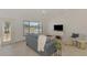 Comfortable living room featuring a plush blue sofa, tiled floors, and a serene view through the window at 13648 Clara Ln, Port Charlotte, FL 33981