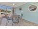 Enclosed lanai with tile flooring, round metal table and four matching chairs with striped cushions at 13648 Clara Ln, Port Charlotte, FL 33981