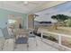 Inviting screened patio features tile flooring, a metal table and four chairs with striped cushions at 13648 Clara Ln, Port Charlotte, FL 33981