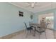 Relaxing patio with blue walls, tile flooring, metal table and chairs, and sliding glass door at 13648 Clara Ln, Port Charlotte, FL 33981