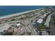 Aerial view of a charming beach neighborhood featuring a roundabout, local shops, and ocean views at 140 Hermes Rd, Venice, FL 34293