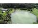 Aerial view showcases a serene lake with sandy shoreline, complete with trees and ample space for recreation at 140 Hermes Rd, Venice, FL 34293
