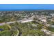 Expansive aerial view capturing the town's layout, with houses, roads, and a distant ocean view at 140 Hermes Rd, Venice, FL 34293