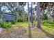 Lush backyard with mature trees, screened-in porch, and a serene setting surrounded by nature at 140 Hermes Rd, Venice, FL 34293