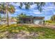 Large backyard features a screened porch, picnic table and is surrounded by mature trees and greenery at 140 Hermes Rd, Venice, FL 34293
