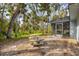 Secluded backyard with a picnic table, gravel, mature trees and access to screened in porch at 140 Hermes Rd, Venice, FL 34293
