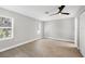A simple bedroom with wood floors, a ceiling fan and two windows with bright sunlight at 140 Hermes Rd, Venice, FL 34293
