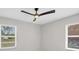 Sunlit bedroom with wood floors, a ceiling fan, and two large windows at 140 Hermes Rd, Venice, FL 34293