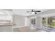 Bright living room featuring wood floors, ceiling fan, and sliding glass doors to a patio at 140 Hermes Rd, Venice, FL 34293