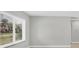 Bright living room features a window with blinds, baseboard trim, and neutral paint at 140 Hermes Rd, Venice, FL 34293