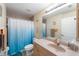 Bathroom with a shower, toilet, vanity, a blue bathmat, and towel racks at 14124 Kewanee Ln, Port Charlotte, FL 33981