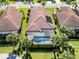 Aerial view of house with pool in enclosed lanai, surrounded by mature Palm trees and manicured lawn at 162 Palazzo Ct, North Venice, FL 34275