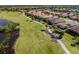Gorgeous aerial view of a home with a tile roof on a golf course with mature Palm trees at 162 Palazzo Ct, North Venice, FL 34275