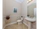 Powder room features a pedestal sink, toilet and neutral colors at 162 Palazzo Ct, North Venice, FL 34275