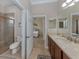 Bright bathroom featuring a tiled shower, commode, and vanity with marble countertops at 162 Palazzo Ct, North Venice, FL 34275