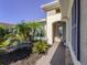 Inviting front entrance with brick paved walkway, bench, and lush landscaping under a clear blue sky at 162 Palazzo Ct, North Venice, FL 34275