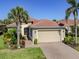 Charming home with a tile roof, two-car garage, brick paved driveway, and lush tropical landscaping at 162 Palazzo Ct, North Venice, FL 34275
