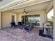 Covered brick patio with comfortable seating, ceiling fan, and outdoor grill, perfect for entertaining at 162 Palazzo Ct, North Venice, FL 34275