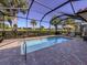 Private screened-in pool area with a brick patio, lounge chairs, and lush tropical landscaping at 162 Palazzo Ct, North Venice, FL 34275