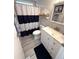 Updated bathroom featuring white vanity, new fixtures, and a shower/tub with a stylish curtain at 175 Palm Harbor Dr, North Port, FL 34287