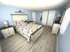Charming bedroom featuring light blue walls, light colored wood floors, and a king bed with beach themed bedding at 175 Palm Harbor Dr, North Port, FL 34287