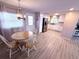 Open-concept dining area features wood-look floors, a round table with seating, and seamless flow to the kitchen at 175 Palm Harbor Dr, North Port, FL 34287